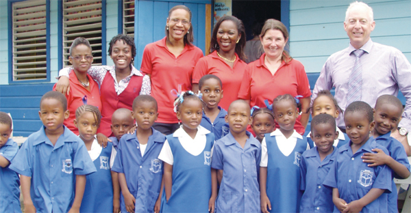 Scotiabank personnel headed by Country Manager Phillip Cross (right) with children at the Dennery Infant School.