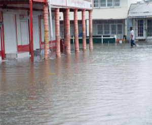A lone pedestrian walks through flooded city street last Saturday.