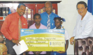 Image of Joseph presenting LUCELEC's $18,000 cheque.