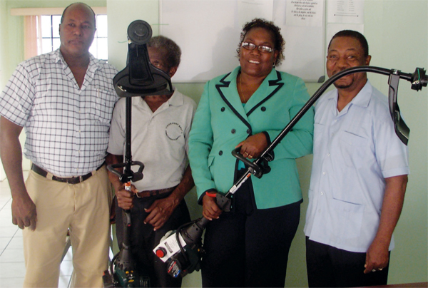 Joshua (right) with Council personnel show off their new weed whackers.