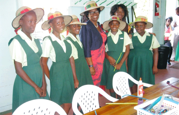 Members of Grow Well's Girls Circle model hats they are designing for the Governor General.