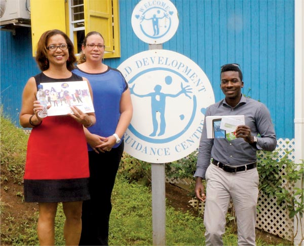 Sales and Customer Care Manager from Winfresh Limited, Mrs. Renee De Myers (left) and Kuan Millar (right) from Liive Productions Inc. makes donation to Dr. Kim Gardner from the Child Development and Guidance Centre (CDGC).