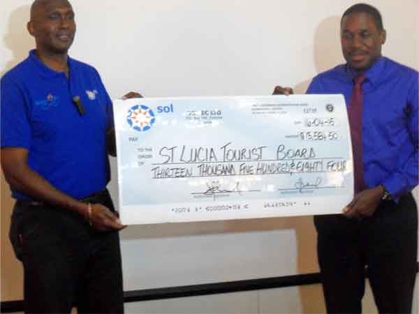 Mc Naughton (left) handing over a cheque to Louis Lewis, Director, Saint Lucia Tourist Board. According to Lewis the money will go towards the educational component of the Saint Lucia Jazz and Arts Festival.