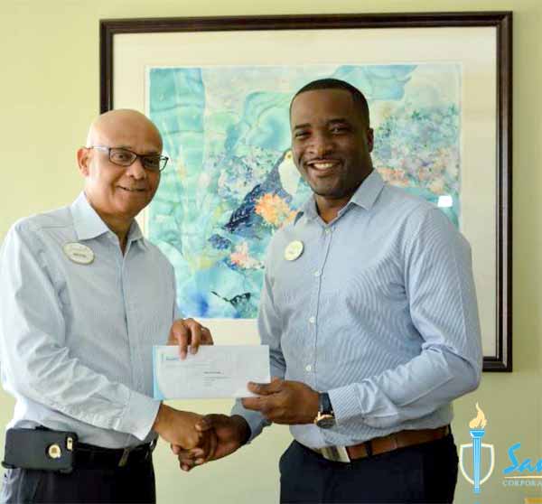 Trevor King (right) receives his scholarship grant from General Manager of Sandals Regency La Toc Golf Resort and Spa Michael James for his pursuit of a Master's Degree in Business Administration at the Australian Institute of Business.