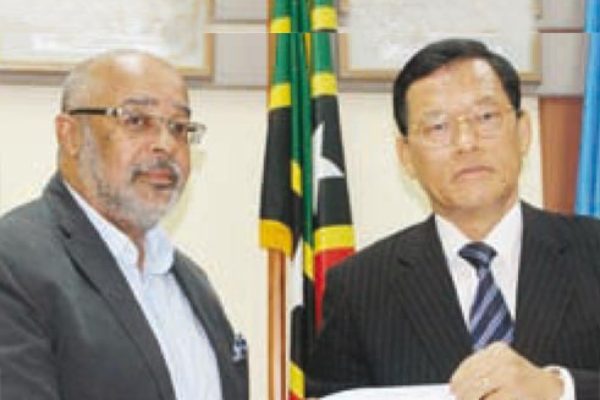 OECS Director-General, Dr. Didacus Jules, receives the cheque on Dominica's behalf from Taiwan's Ambassador to Saint Lucia, James Chang.