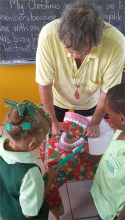 Dentist Neil Stephen demonstrates proper brushing techniques to the children of Gros Islet Infant School during a recent visit.