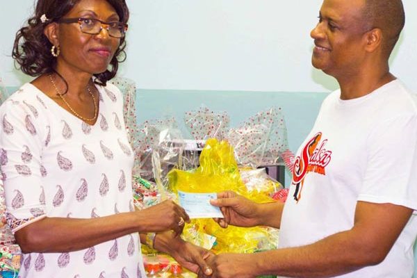Image: Dr. St. Rose presents a hamper and cheque to Ms.Prisca St. Paul of Upton Gardens.