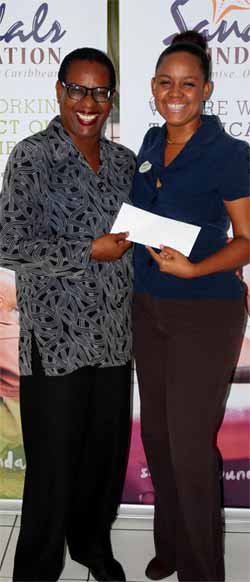 Ms.Laborde (left) receives Sandals cheque.