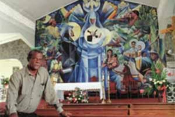 Sir Dunstan St. Omer with his mural at Jacmel Catholic Church.