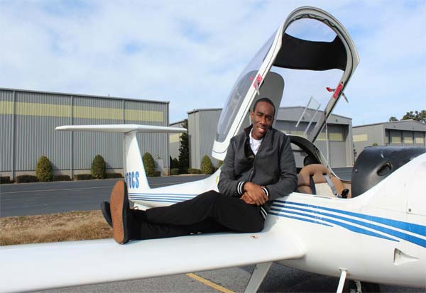 Tevin Belasco relaxes on the wing of an aircraft....his dream is to fly commercially.