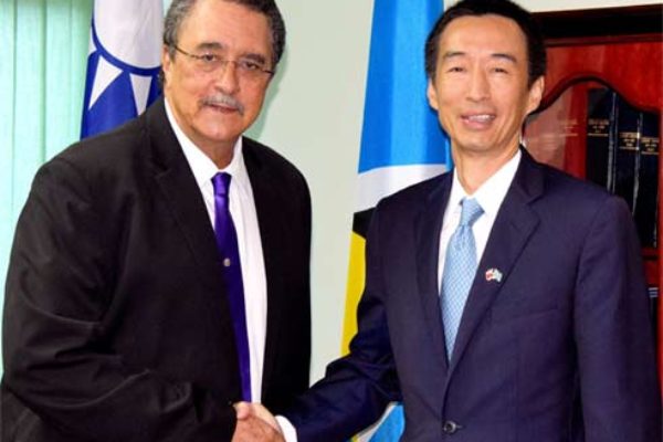 Ambassador Mou and Prime Minister Anthony shake hands at the cheque presentation ceremony
