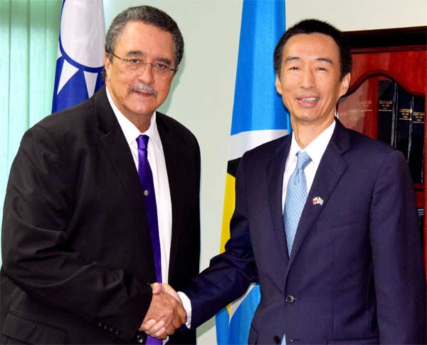 Image: Ambassador Mou and Prime Minister Anthony shake hands at the cheque presentation ceremony.