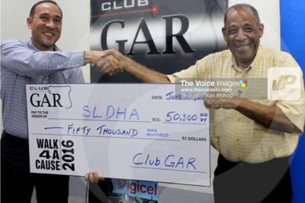 img: Club Gar’s Gordon Charles (left) presents SLDHA’s George Eugene with the ceremonial cheque. [PHOTO: Stan Bishop]