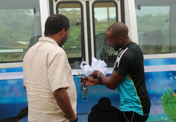 Image: (L-R) SLFA President Lyndon Cooper and Elite athlete Javelin thrower Albert Reynolds cut the ribbon commissioning St. Lucia team bus.