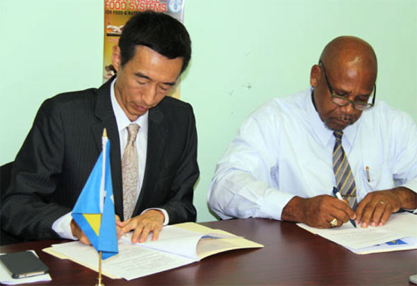 Image: Ambassador Mou and Minister Joseph sign the action plan.