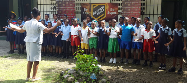 img: La Croix Maingot Combined School choir performing after receiving a suprise donation from SuperMalt.