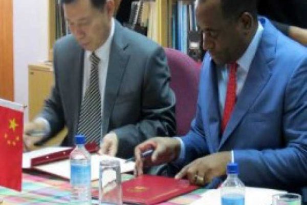 Image: Prime Minister Roosevelt Skerrit (right) and China Ambassador Lu Kun, signing agreements