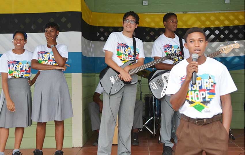 Image of Ange Fontenelle with students fom Corinth Secondary band.