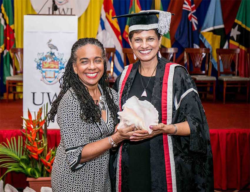 Image: Dr. Luz Longsworth (right) and her friend and colleague, Marguerite Orane share a light moment with a Queen Conch shell.
