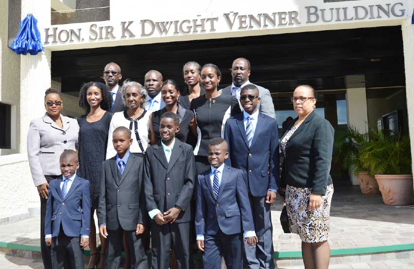 Image: The Venner family pose for a photo in front of the building.