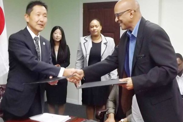Image: The exchange of documents for the purchase of the ambulance between St. Jude Hospital Board Chairman, Dr. Ulric Mondesir and Japanese Ambassador Mr. Mitsuhiko Okada
