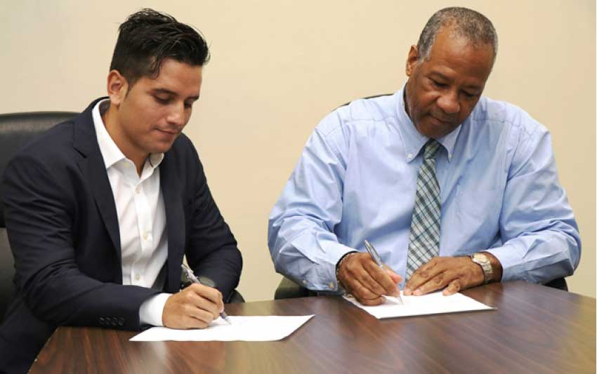 iMAGE: LUCELEC’s Managing Director, Trevor Louisy, and a GRUPOTEC representative at the contract signing ceremony.
