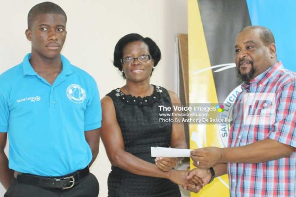 Image: Husbands presenting SLFA Scholarship to a parent of a young footballer. (PHOTO: Anthony De Beauville)