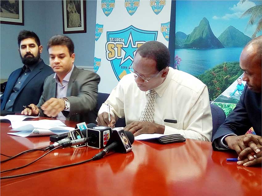 Image: Pandya and Montoute sign the agreement yesterday. [PHOTO BY PhotoMike]