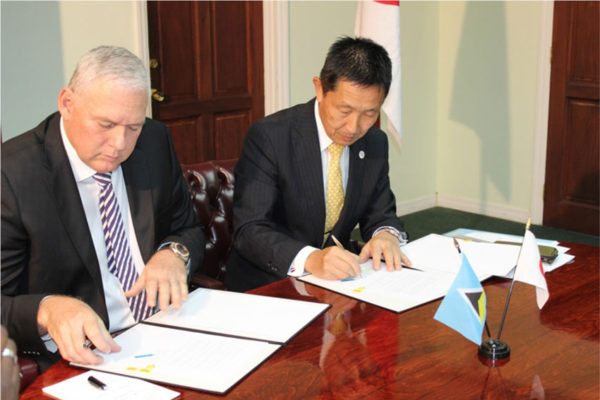 img: Prime Minister Allen Chastanet and Japan’s Ambassador to St. Lucia H.E. Mitsuhiko Okada signing the agreement, which is said to be one of the most ambitious of aid provided by Japan to St. Lucia.
