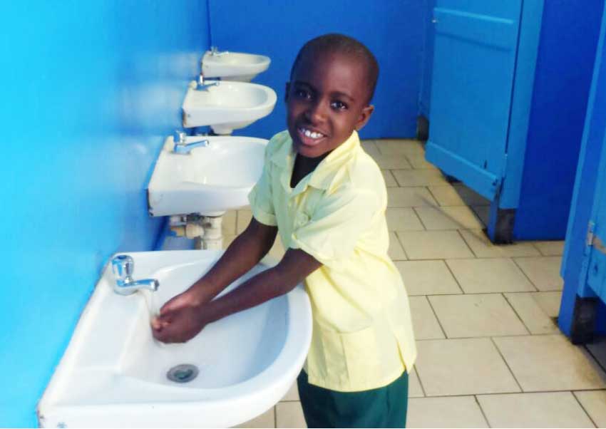 Image of one of the Balata Government School students making use of the refurbished bathroom facility at his school.