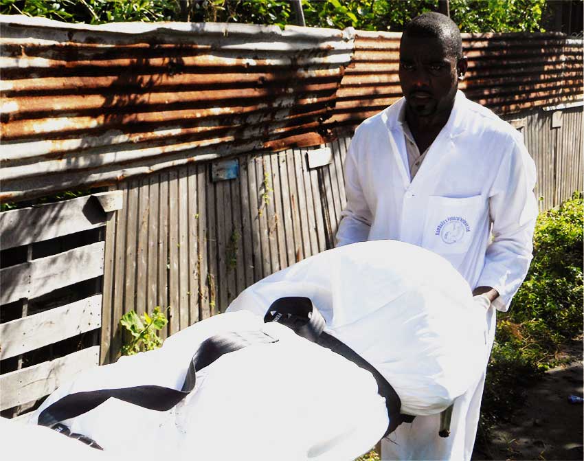 Image of Rambally Funeral Parlour staff removing one of the bodies.