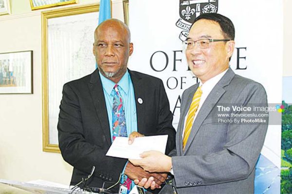 Image: Castries Mayor Peterson Francis receives the cheque from Taiwanese Ambassador Douglas Shen last Thursday. (PhotoMike)