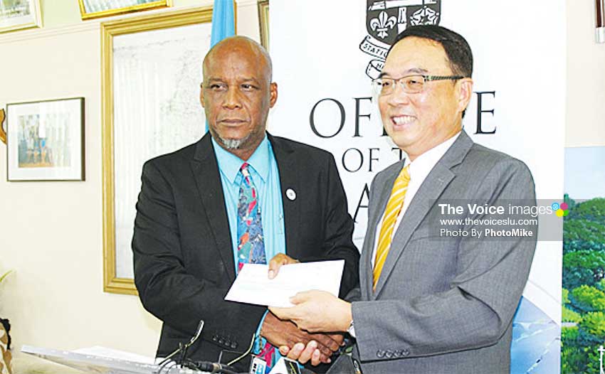 Image: Castries Mayor Peterson Francis receives the cheque from Taiwanese Ambassador Douglas Shen last Thursday. (PhotoMike)
