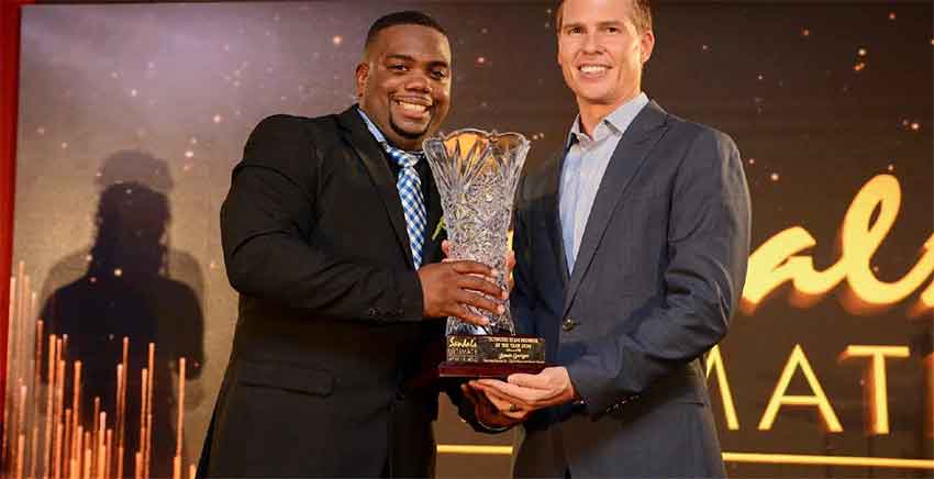 Image: Jamer Georges, the Ultimate Team Member of the Year for the Sandals ATL Group, pauses from his usual energetic antics to collect the top trophy from the company’s Deputy Chairman and CEO, Adam Stewart.