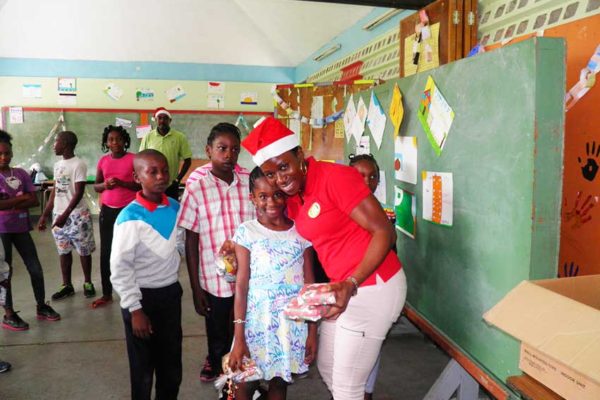 Image: OECS Staff distributing gifts during the Toy Drive to Dominica.