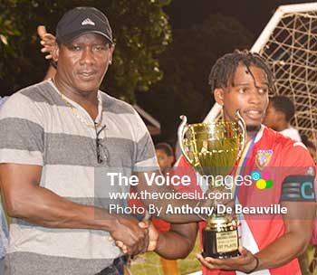 Image: Parliamentary representative for Gros Islet Lenard Montoute presenting the ‘Spider Cup’ to KFC–GMC United captain Charlery Mathurin. (Photo: Anthony De Beauville)