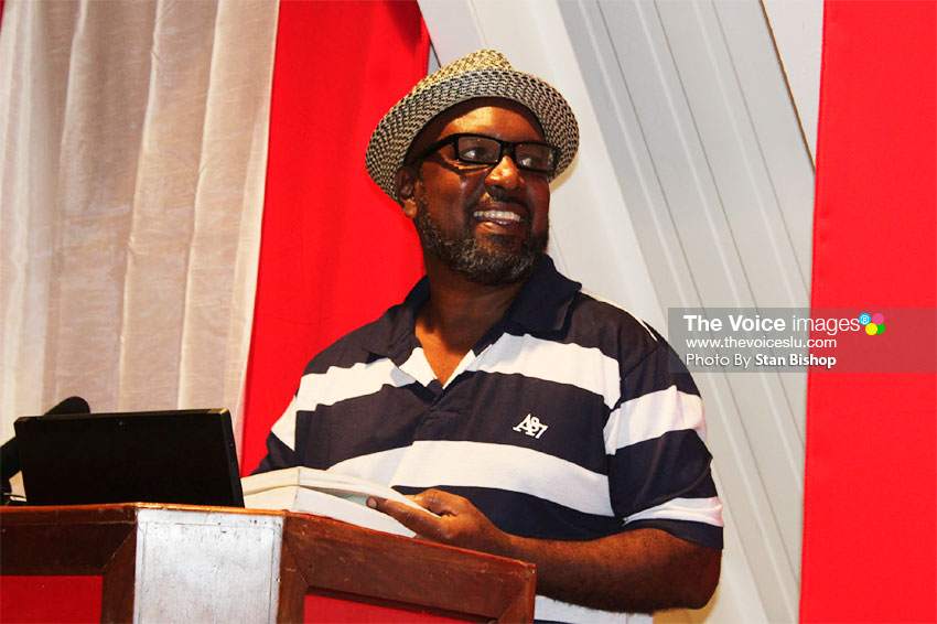 Image: Dr. Travis Weekes reads poems by Sir Derek Walcott. [PHOTO: Stan Bishop]