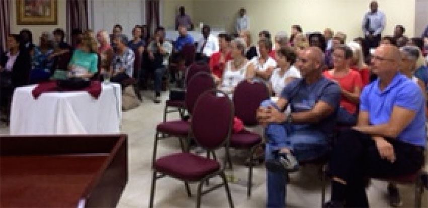 Image: Members of the 100 Women and Men St. Lucia listen attentively to the charity presentation.