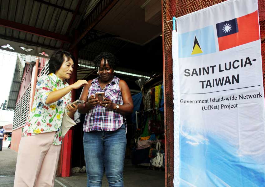 Image of Taiwanese project manager, Karen Kuo explaining the GiNet WIFI service to local people.