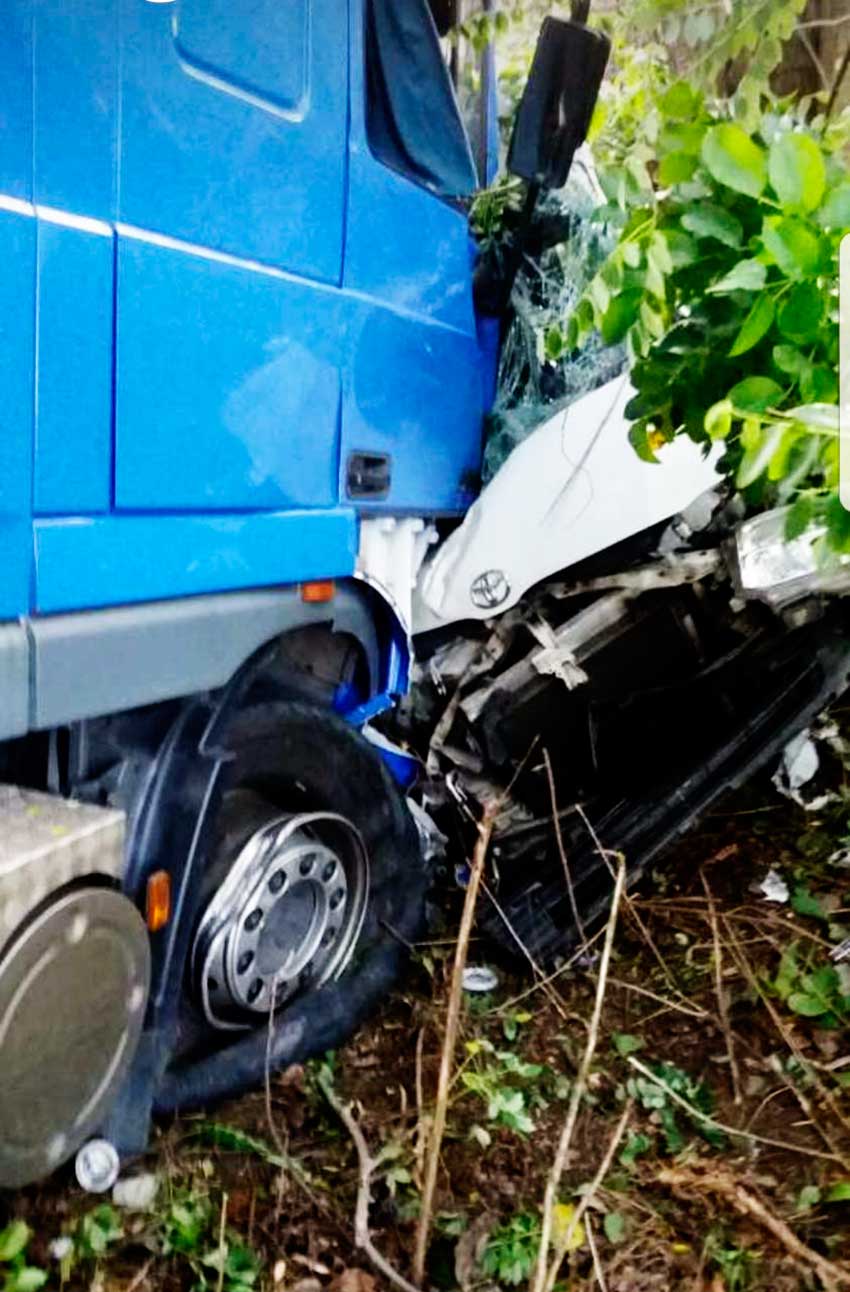 Image of Minibus mangled under lorry