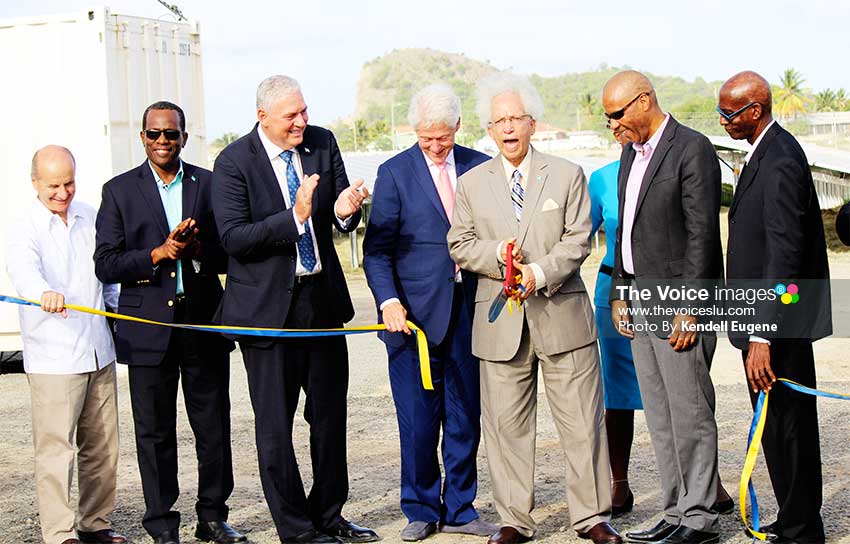 Image: OPEN SESAME! The Prime Minister, Opposition Leader, President Clinton, LUCELEC Managing Director and Board Chairman in joint applause as Governor General Sir Winston Cenac cuts the ribbon at La Tourney to launch the island's First Solar Farm. (PHOTO: Kendell Eugene)