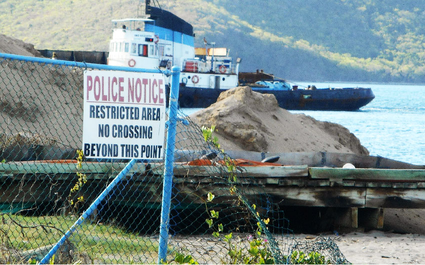 Image of the usual berth of the Southern Marine Police vessel is now empty against the background of a rising mountain of sand.