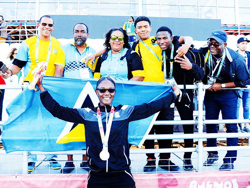 Image: Julien Alfred celebrate with members of Team Saint Lucia in the back, (l-r) Brian Charles (Swimming Coach), Alfred Emmanuel ( SLOC General Secretary), LiotaCharlemange - Mason ( Chef de Mission), JayhanOdlum - Smith (swimmer), Sheldon St. Rose (Athlete) and Edmund Estaphane (Minister for Youth Development and Sports), missing in photo, Denise Herman (Athletic Coach). (PHOTO: IAAF)