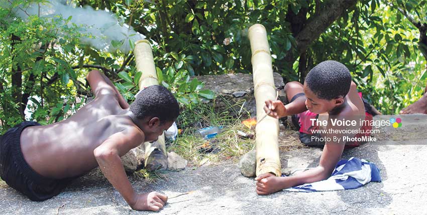 Image: These two young Saint Lucians in Canaries were among many keeping the bamboo-bursting tradition alive Sunday around the island. (Photo by: PhotoMike).