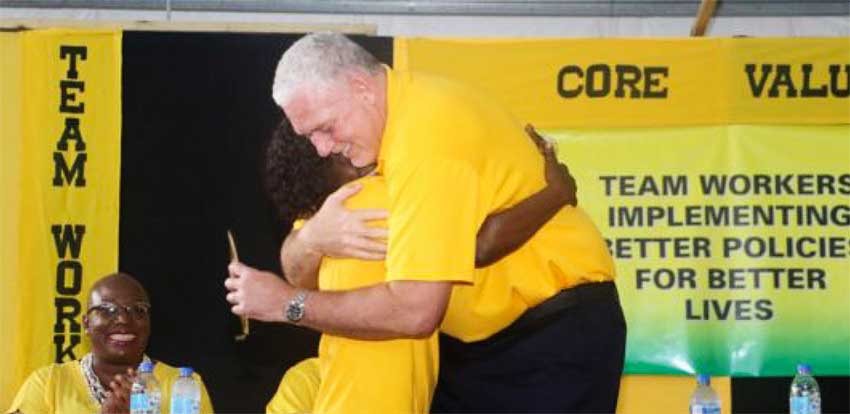 Image of PM Allen Chastanet and a member of the UWP embracing at the party convention