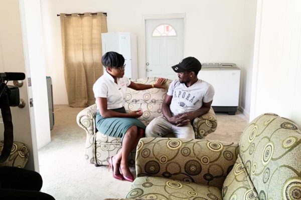 Image: Digicel Marketing Manager Jamisha Wright and $15,000 grand prize winner of a home makeover Leon Brin have a quick chat on his brand new sofa