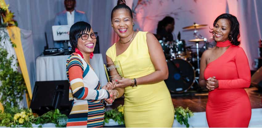 Image: Carmy Joseph accepting an award on behalf of LUCELEC. (PHOTO: Belle Portwe)