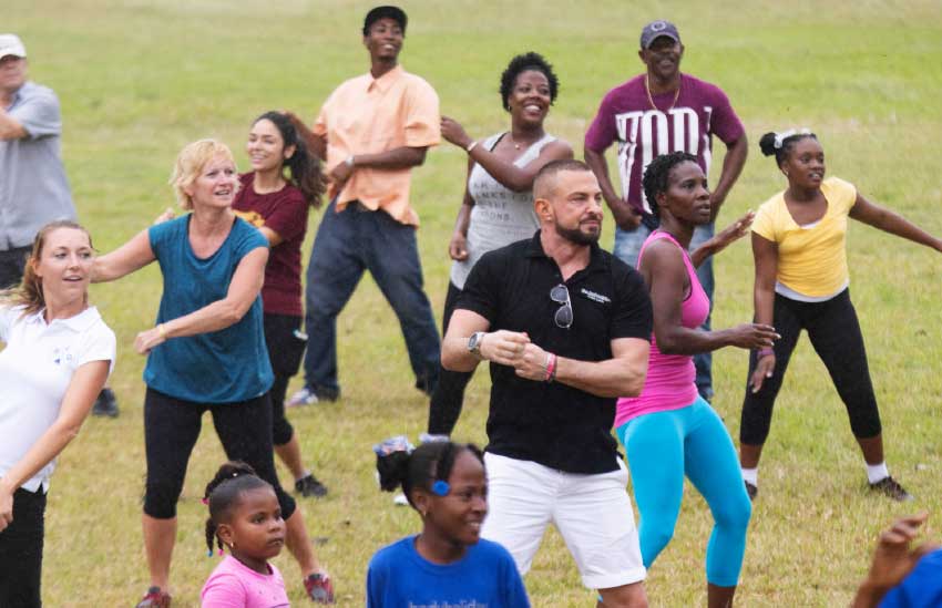Image of the BodyHolday team dancing away with residents of Monchy.