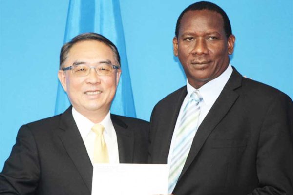 Image of Taiwanese Ambassador to Saint Lucia His Excellency Douglas Cheng and Minister for Equity, Social Justice, Local Government and Empowerment Lenard Montoute displaying one of two cheques representing Taiwan’s generosity to the country’s Constituency Development Programme (CDP).