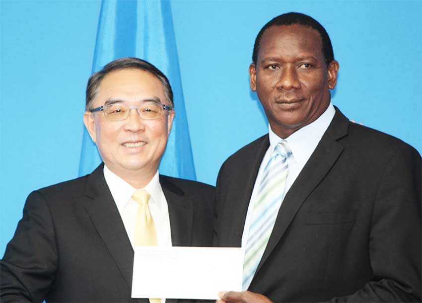 Image of Taiwanese Ambassador to Saint Lucia His Excellency Douglas Cheng and Minister for Equity, Social Justice, Local Government and Empowerment Lenard Montoute displaying one of two cheques representing Taiwan’s generosity to the country’s Constituency Development Programme (CDP).